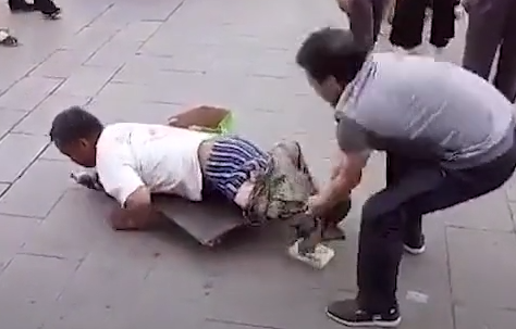 小伙看见一个残疾人乞丐,随后冲上去扒掉外裤,路人们