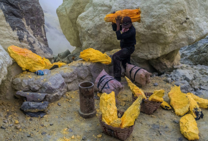 火山口内的喷气孔每天产生大量硫磺,当地人冒着生命危险采集硫磺矿.