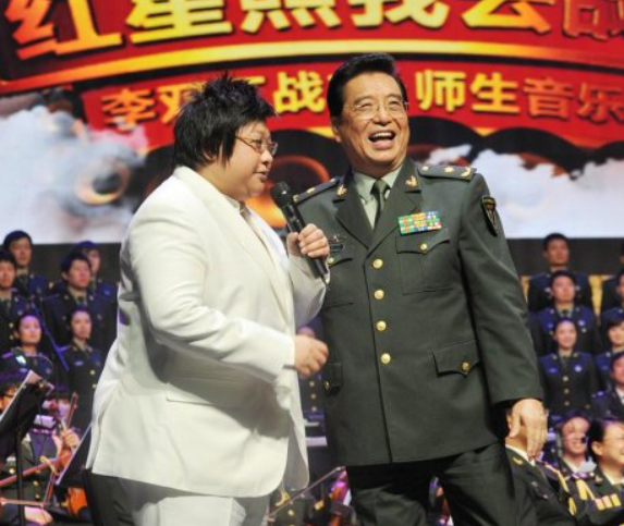 82岁李双江现身音乐会,穿军装登台唱歌,台下观众举手机拍摄